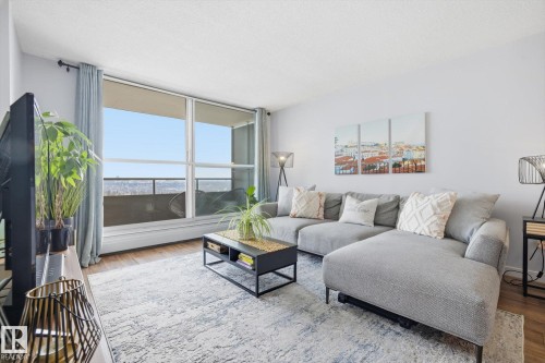 Living area with healthy amount of natural light, wood finished floors, and a textured ceiling - 1513 13910 Stony Plain Road, Edmonton, AB - Indoor Photo Showing Living Room