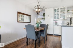 Dining space featuring dark wood-style flooring and a chandelier - 