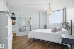 Bedroom with dark wood-type flooring and a chandelier - 