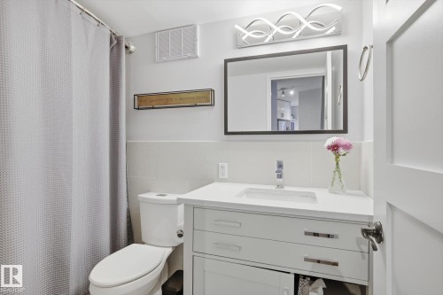 Bathroom with vanity, a shower with curtain, tile walls, and wainscoting - 1513 13910 Stony Plain Road, Edmonton, AB - Indoor Photo Showing Bathroom
