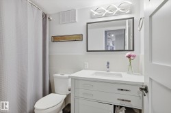 Bathroom with vanity, a shower with curtain, tile walls, and wainscoting - 