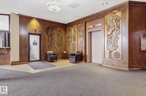 Lobby featuring a textured ceiling, wooden walls, and recessed lighting - 1513 13910 Stony Plain Road, Edmonton, AB - Indoor Photo Showing Other Room