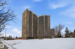 Snow covered building featuring a view of apartment building / complex - 