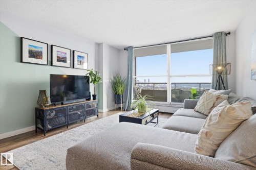 Living area with wood finished floors and baseboards - 1513 13910 Stony Plain Road, Edmonton, AB - Indoor Photo Showing Living Room