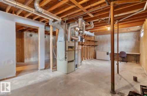 Unfinished basement with fridge and heating unit - 3810 110 Avenue, Edmonton, AB - Indoor Photo Showing Basement