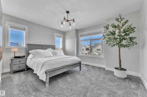 Bedroom featuring carpet flooring and a chandelier - 7613 16 Ave Sw, Edmonton, AB - Indoor Photo Showing Bedroom