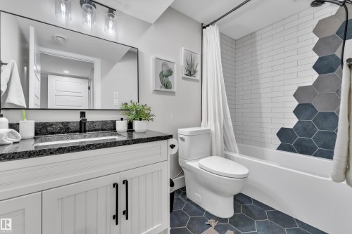 Full bathroom featuring shower / bathtub combination with curtain, vanity, and dark tile patterned flooring - 7613 16 Ave Sw, Edmonton, AB - Indoor Photo Showing Bathroom