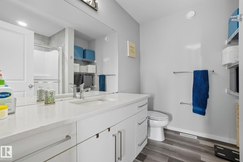 Bathroom featuring a stall shower, vanity, and dark wood-style flooring - 2039 Wonnacott Way, Edmonton, AB - Indoor Photo Showing Bathroom