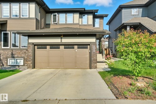 View of front of house featuring stone siding, driveway, and a garage - 2039 Wonnacott Way, Edmonton, AB - Outdoor With Facade