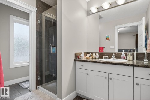 Full bath with vanity, a shower stall, tasteful backsplash, and dark tile patterned floors - 9858 72 Avenue, Edmonton, AB - Indoor Photo Showing Bathroom
