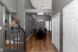 Dining room with laminate flooring, high vaulted ceiling, and a chandelier - 