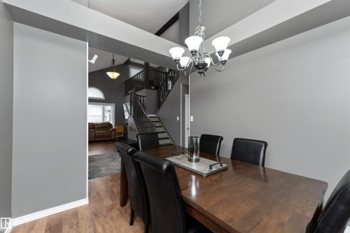 Dining room featuring laminate flooring, a chandelier, and high vaulted ceiling - 5628 188A Street, Edmonton, AB - Indoor Photo Showing Dining Room