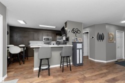 Kitchen with light countertops, dinette, a breakfast bar area, backsplash, stainless steel appliances - 