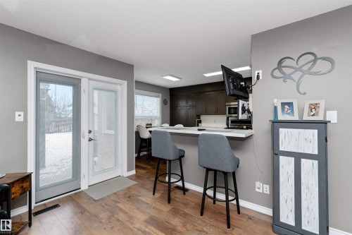 Kitchen with light countertops, dinette, a breakfast bar area, backsplash, appliances with stainless steel finishes - 5628 188A Street, Edmonton, AB - Indoor