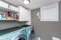 Laundry room off the garage on the main floor, with washer and clothes dryer, and cabinet space - 