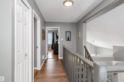Hallway featuring an upstairs landing, laminate flooring - 