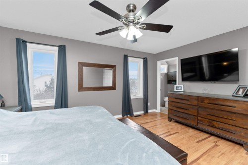 Spacious primary bedroom with an accent wall, laminate flooring, 4-piece ensuite and walk-in closet - 5628 188A Street, Edmonton, AB - Indoor Photo Showing Bedroom