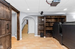 Theatre room featuring tiered seating, projector, motorized screen, and built-in shelving - 