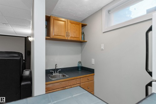 Wet bar with sink and fridge located conveniently in the theatre room - 5628 188A Street, Edmonton, AB - Indoor