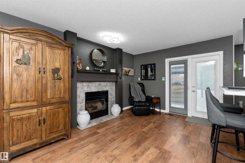 Family room featuring a fireplace with flush hearth, laminate flooring - 5628 188A Street, Edmonton, AB - Indoor With Fireplace