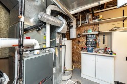 Utility room featuring furnace, HWT, and small workshop area - 