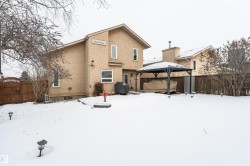 Snow covered property featuring a fenced backyard, stucco siding, a gate, and a gazebo - 