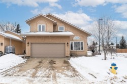 View of front of house with an attached garage, stucco siding, and concrete driveway - 