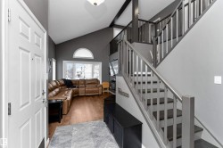 Stairs featuring laminate flooring and a vaulted ceiling - 
