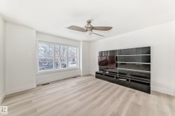 Unfurnished living room featuring light wood-style flooring and a ceiling fan - 