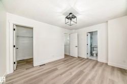 Unfurnished bedroom with a walk in closet, light wood-type flooring, and ensuite bath - 