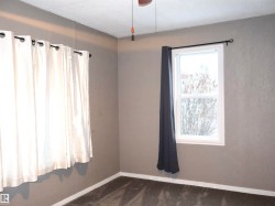 Unfurnished room with baseboards and dark colored carpet - 