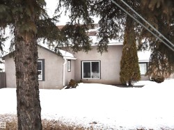 Snow covered back of property with stucco siding - 