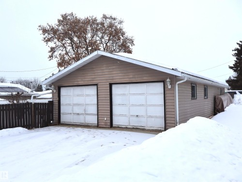 Snow covered garage featuring a garage - 4511 53 Ave, Barrhead, AB - Outdoor