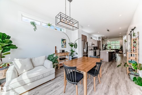 Dining room featuring light wood-type flooring and a barn door - 8321 80 Avenue, Edmonton, AB - Indoor