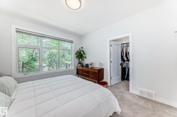 Bedroom featuring a walk in closet and light colored carpet - 