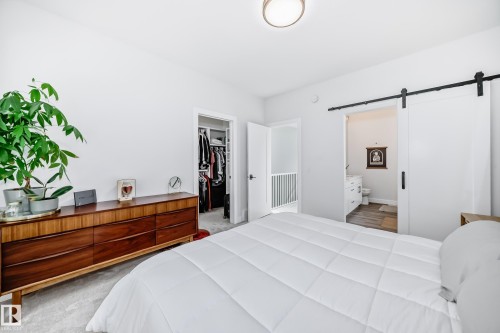 Bedroom with a barn door, a walk in closet, and connected bathroom - 8321 80 Avenue, Edmonton, AB - Indoor Photo Showing Bedroom