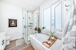 Full bathroom with a marble finish shower, light wood finished floors, vanity, and a soaking tub - 