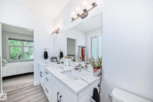 Full bathroom with connected bathroom, double vanity, and light wood finished floors - 8321 80 Avenue, Edmonton, AB - Indoor Photo Showing Bathroom