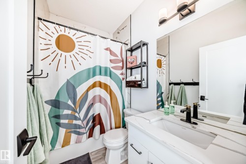 Full bath featuring vanity, shower / bath combo with shower curtain, and light wood finished floors - 8321 80 Avenue, Edmonton, AB - Indoor