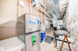 Unfinished basement with light wood-style floors and freestanding refrigerator - 