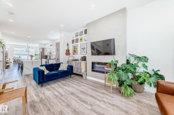 Living area featuring light wood-style floors, a glass covered fireplace, and recessed lighting - 