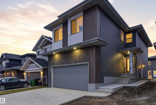 Contemporary home with an attached garage, concrete driveway, and stone siding - 2532 210 Street, Edmonton, AB - Outdoor With Facade