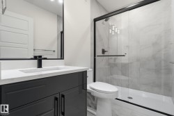Bathroom featuring a marble finish shower, vanity, and light marble finish flooring - 
