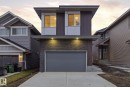 Contemporary home featuring concrete driveway, an attached garage, board and batten siding, and stone siding - 2532 210 Street, Edmonton, AB  - Outdoor 