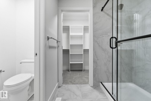 Full bathroom with a marble finish shower, light marble finish floors, and a walk in closet - 2532 210 Street, Edmonton, AB - Indoor Photo Showing Bathroom