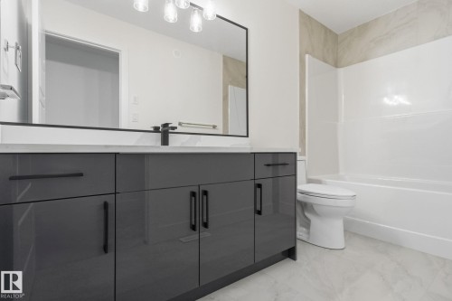 Full bathroom with vanity, tub / shower combination, and light marble finish floors - 2532 210 Street, Edmonton, AB - Indoor Photo Showing Bathroom