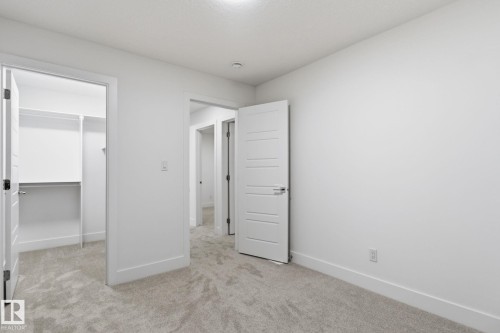 Unfurnished bedroom with a spacious closet and light colored carpet - 2532 210 Street, Edmonton, AB - Indoor