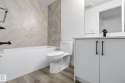 Full bath with vanity, light wood finished floors, and washtub / shower combination - 