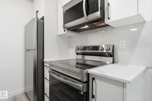 Kitchen with stainless steel appliances, white cabinets, and modern cabinets - 2532 210 Street, Edmonton, AB - Indoor Photo Showing Kitchen
