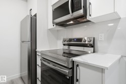 Kitchen with stainless steel appliances, white cabinets, and modern cabinets - 